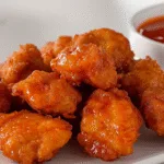 Crispy keto chicken nuggets with dipping sauce on white plate