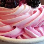 Pinkberry Frozen Yogurt swirl topped with a strawberry and blueberries in a white cup
