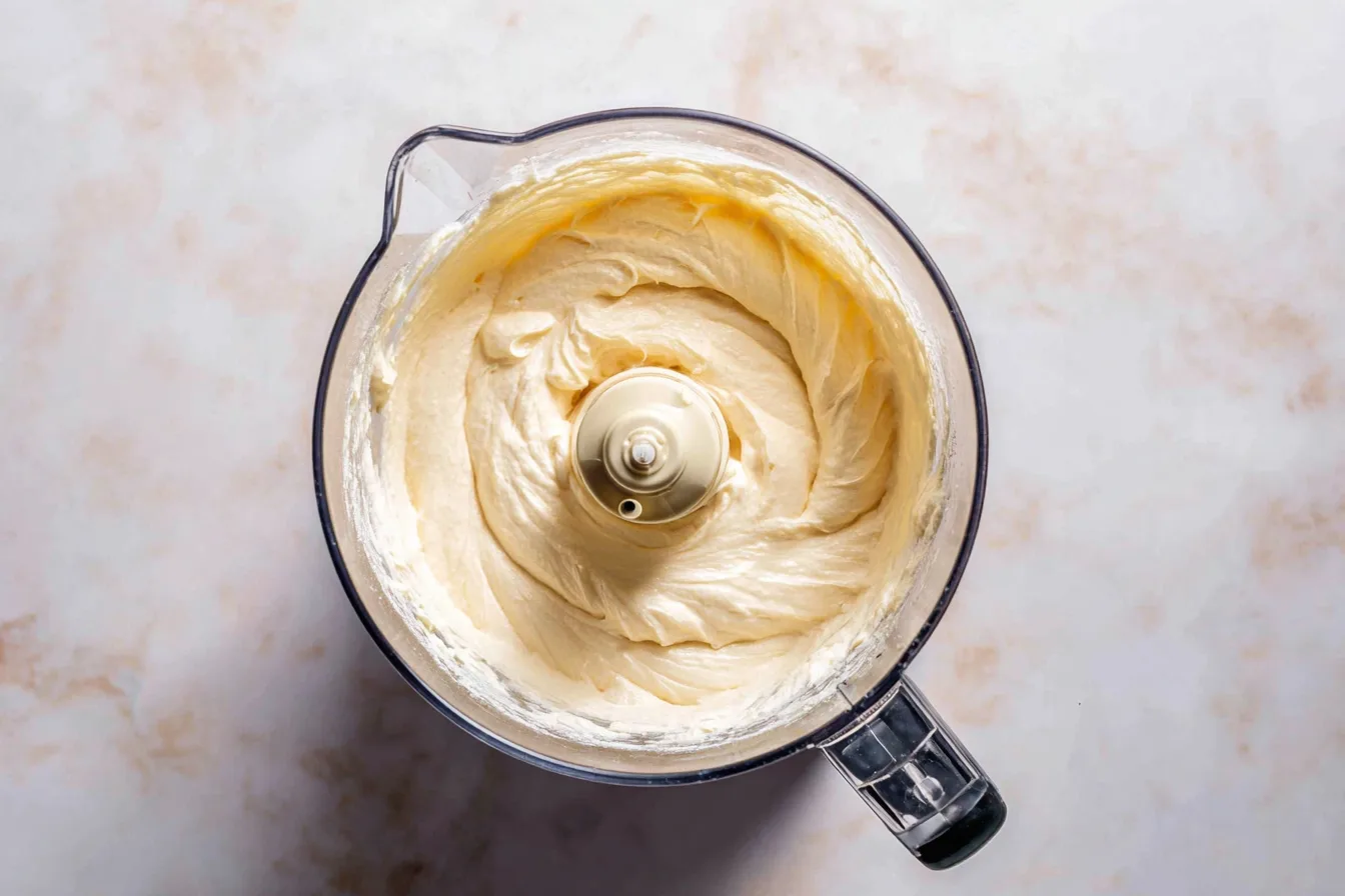 mixing cheesecake filling for cinnamon roll cheesecake