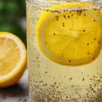 Chia seed lemonade in clear glass with lemon slice near garden background