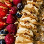 High protein oatmeal with banana, strawberries, raspberries, and blueberries