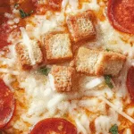 Pizza soup with cheese, pepperoni and crispy croutons on top